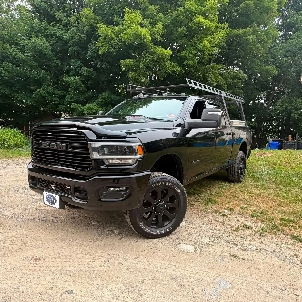 Work truck parked beside trees