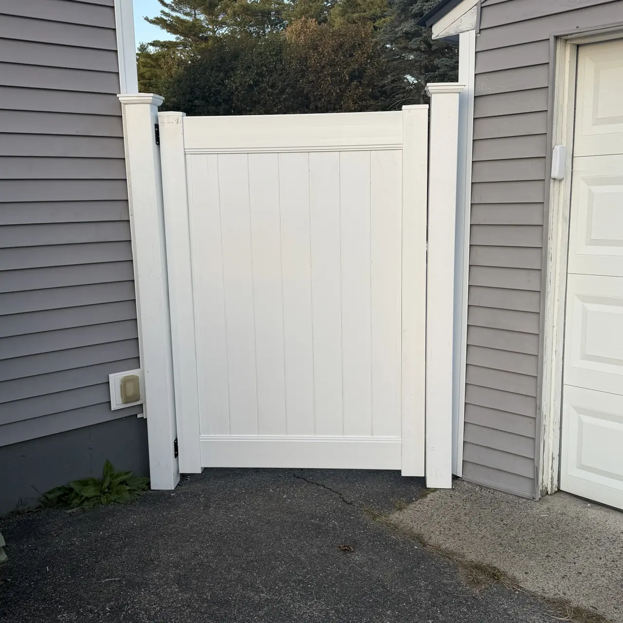 White vinyl privacy gate between buildings